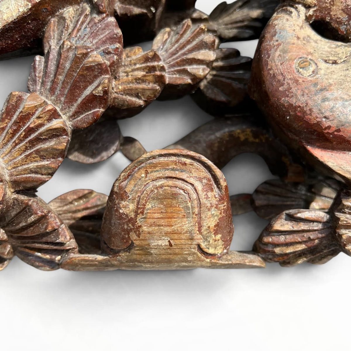 Détail de bois sculpté ancien polychrome aux poissons et coquilles Saint-Jacques