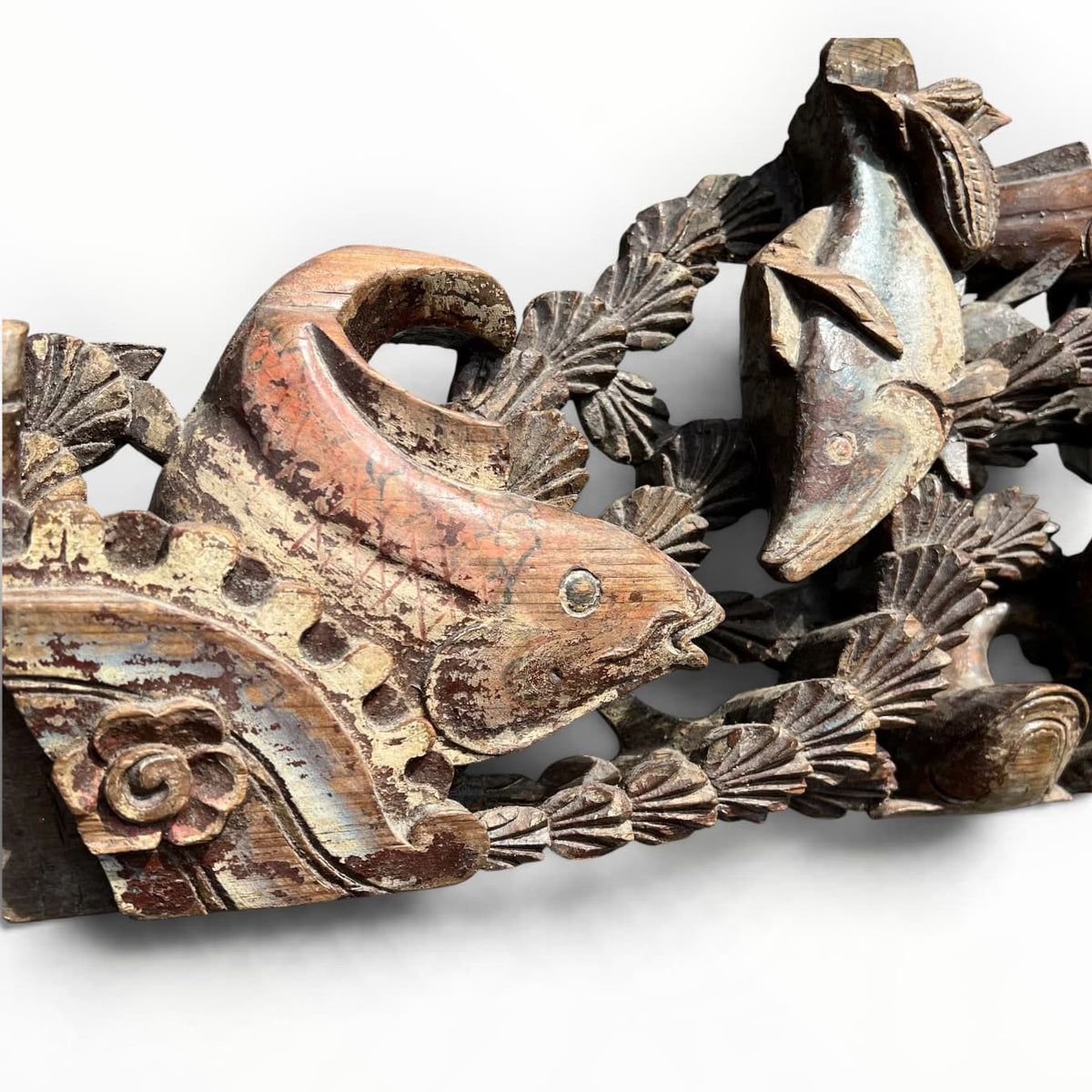 Détail de bois sculpté ancien polychrome aux poissons et coquilles Saint-Jacques
