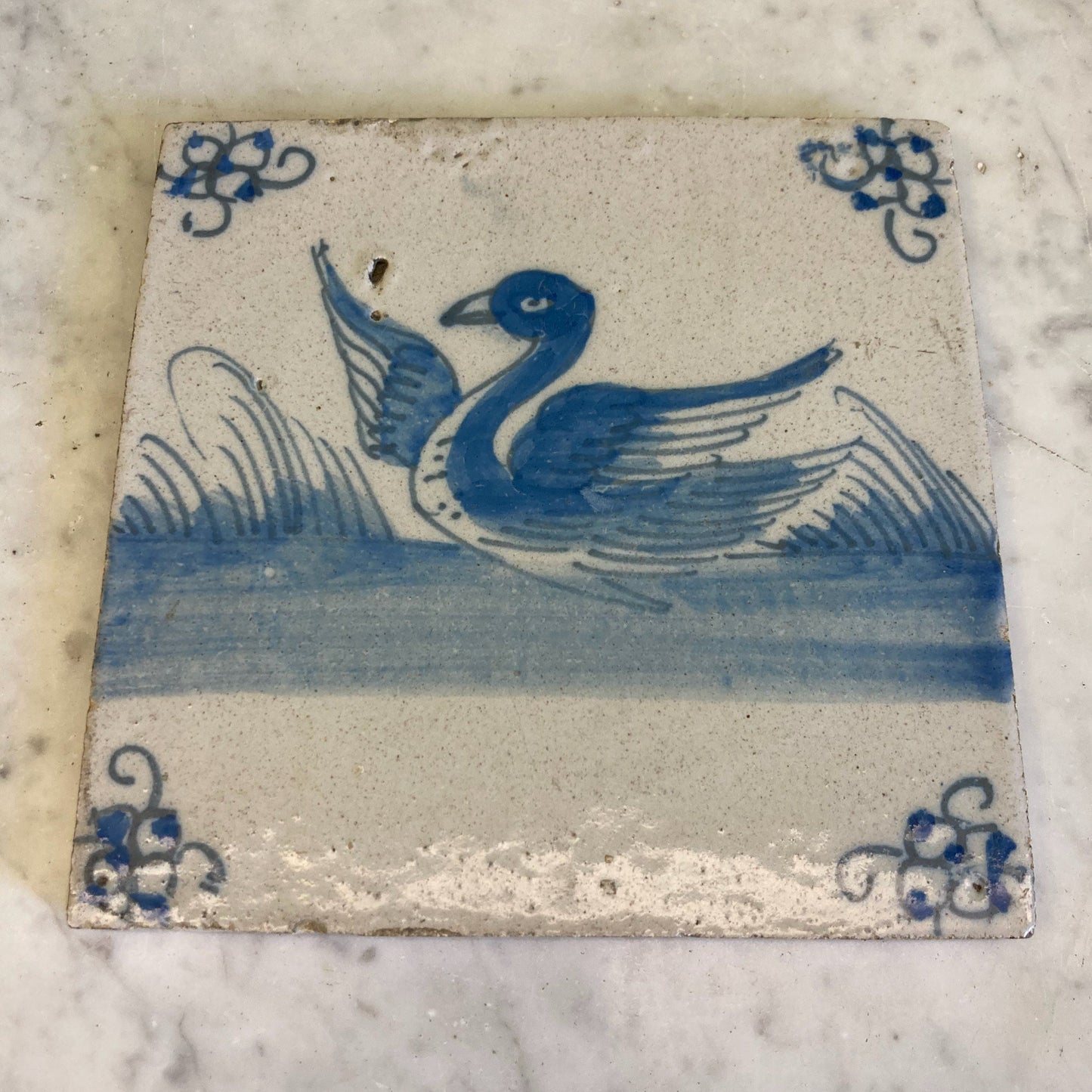 ancien carreau en faïence de Delft à décor d' un cygne en camaieu de bleu