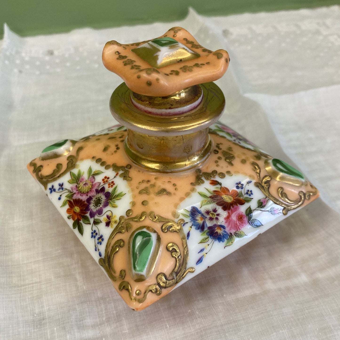 Flacon de parfum ancien en porcelaine polychrome et dorée à décor de fleurs.