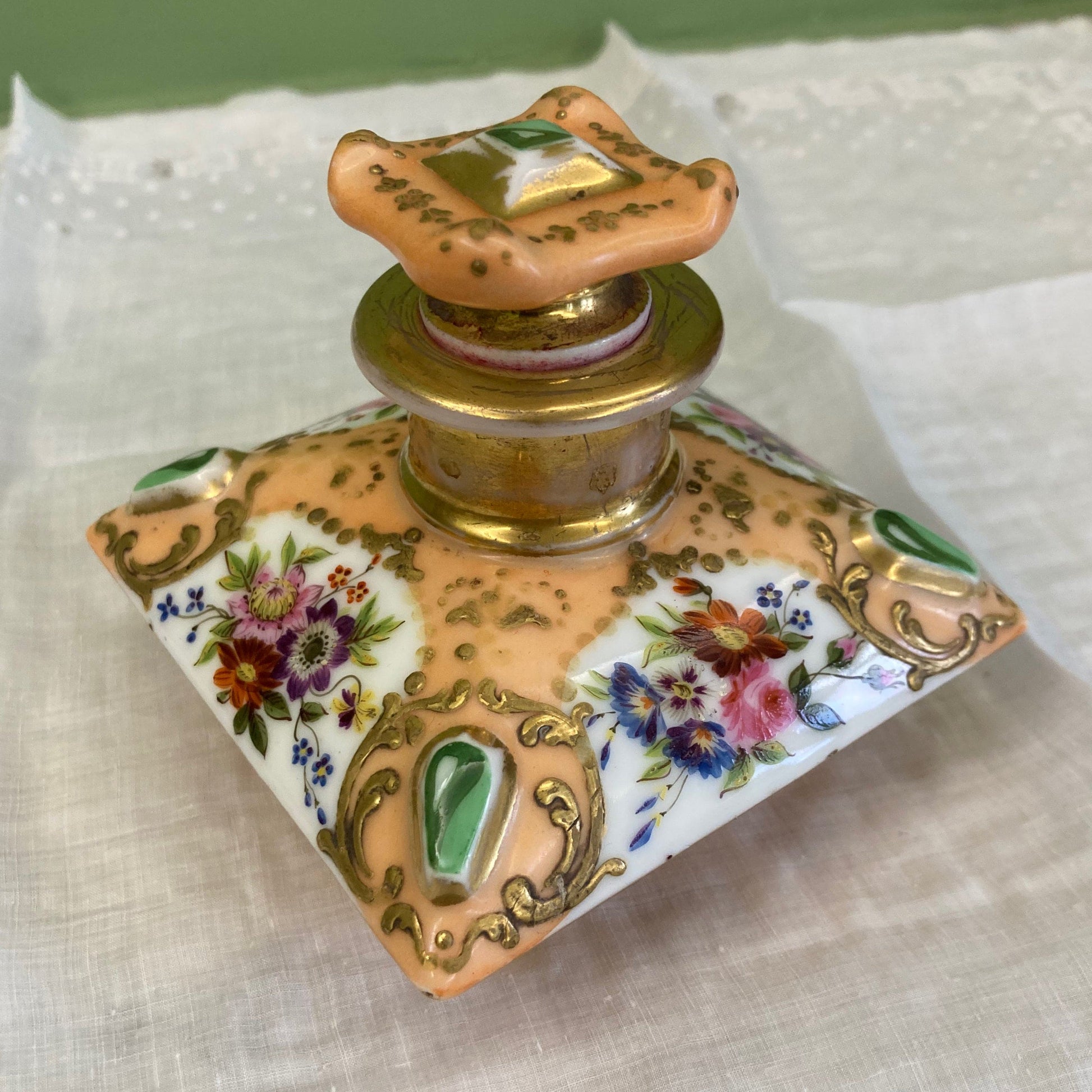 Flacon de parfum ancien en porcelaine polychrome et dorée à décor de fleurs.