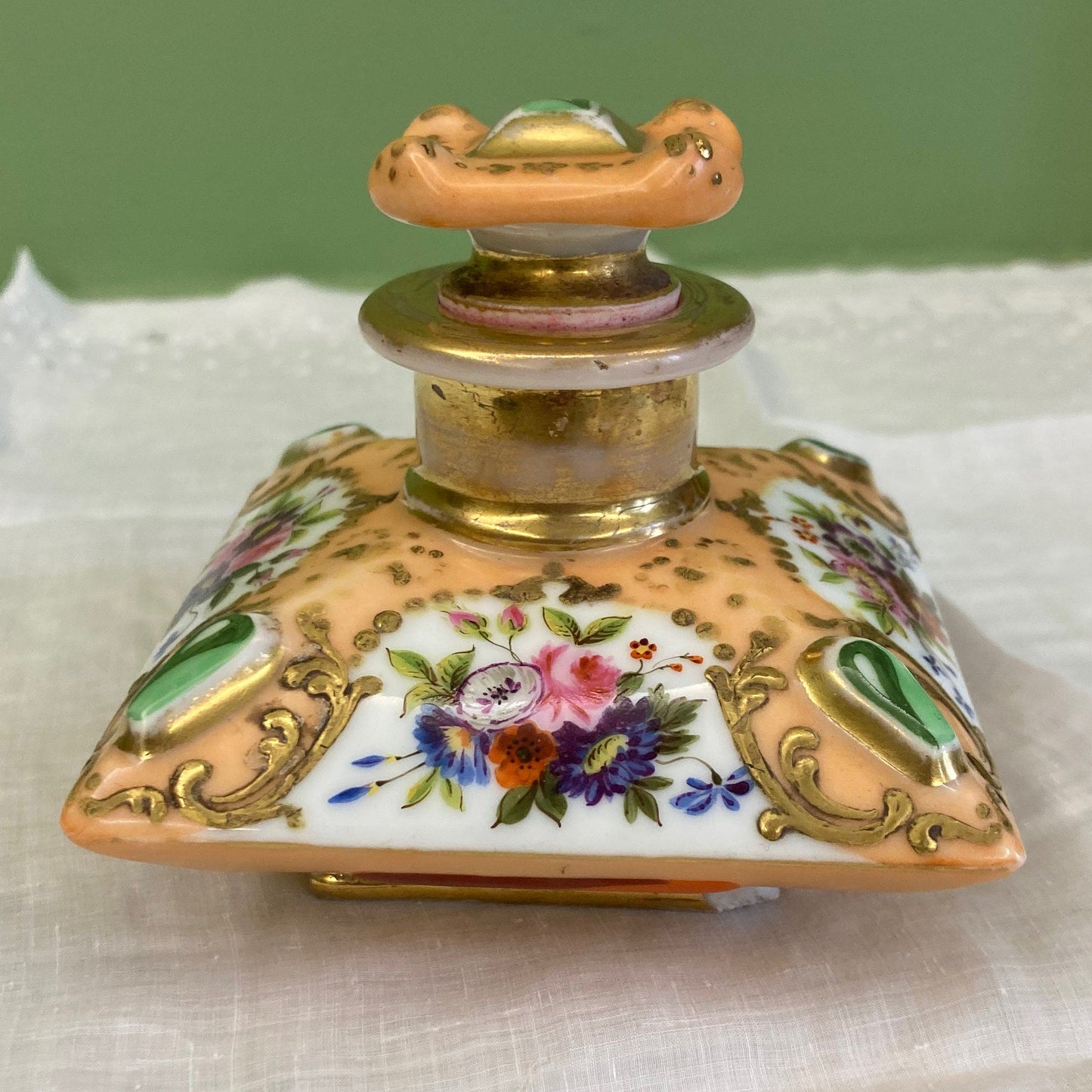 Flacon de parfum ancien en porcelaine polychrome et dorée à décor de fleurs.