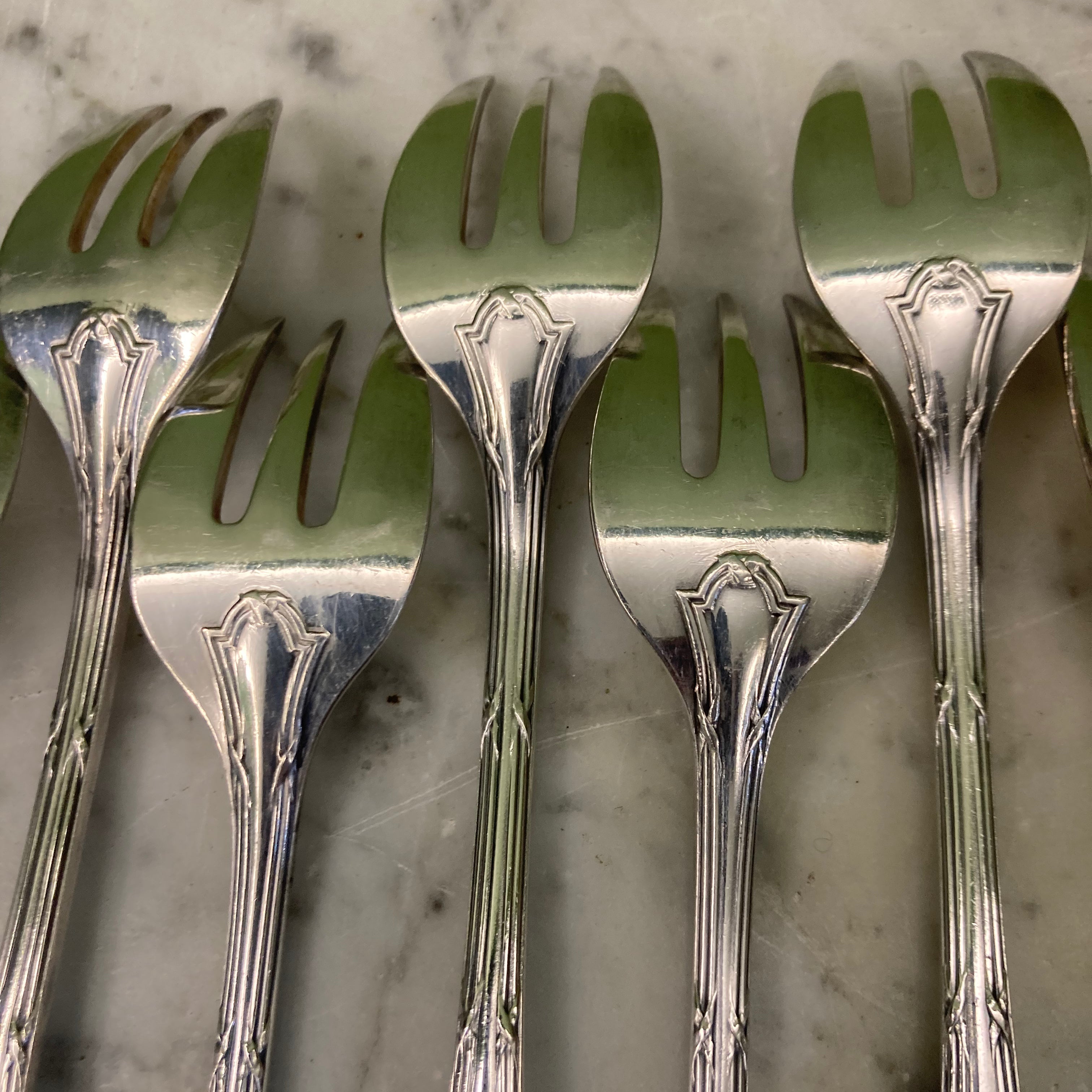 12 fourchettes à huitres de chez Christofle en métal argenté modèle rubans croisés.