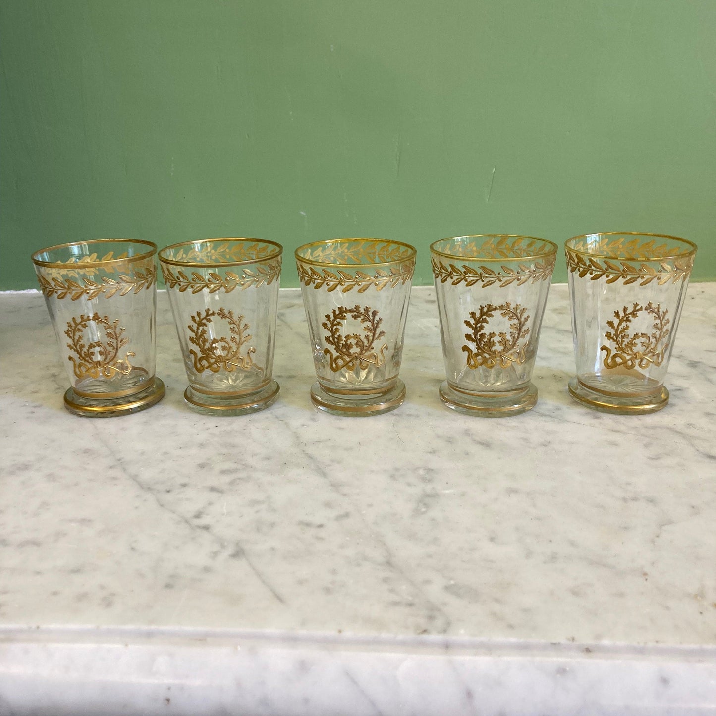 5 gobelets en cristal doré décor frise de laurier et couronne de chêne.