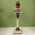 Lampe à pétrole avec réservoir en cristal rose et piétement en albâtre.
