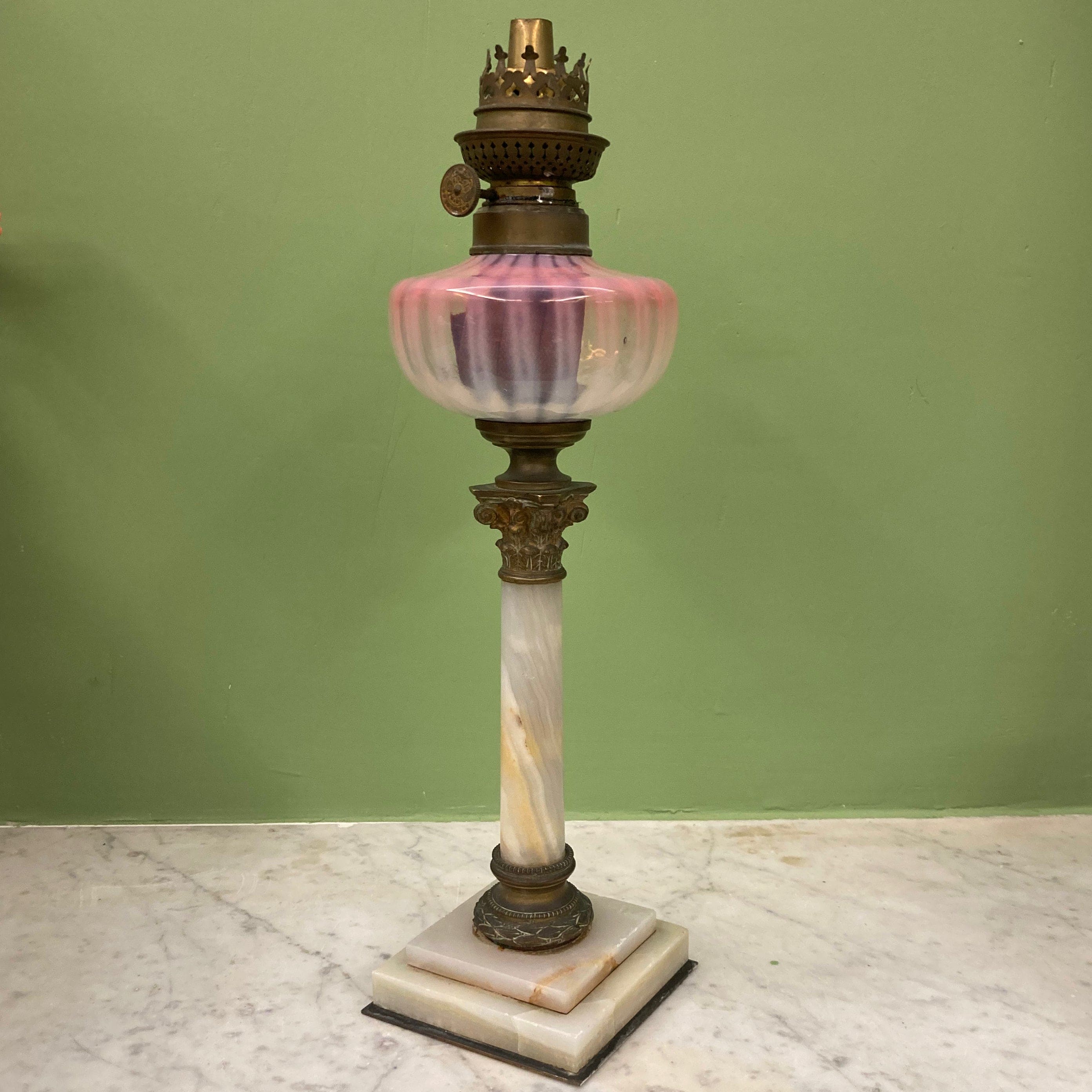 Lampe à pétrole avec réservoir en cristal rose et piétement en albâtre.