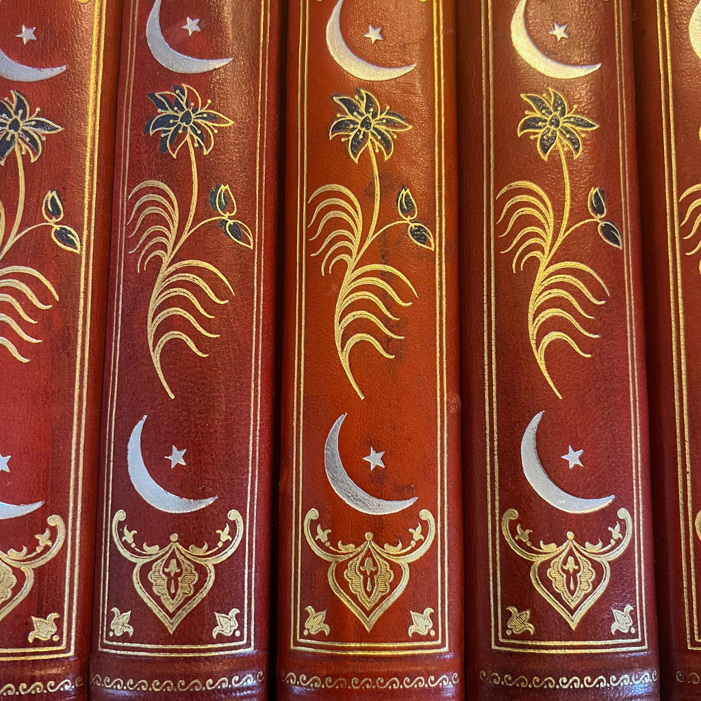 Détail de : Collection complète de huit volumes du Livre des Mille Nuits et Une Nuit de Mardrus, reliés en demi-veau rouge avec décor oriental doré.