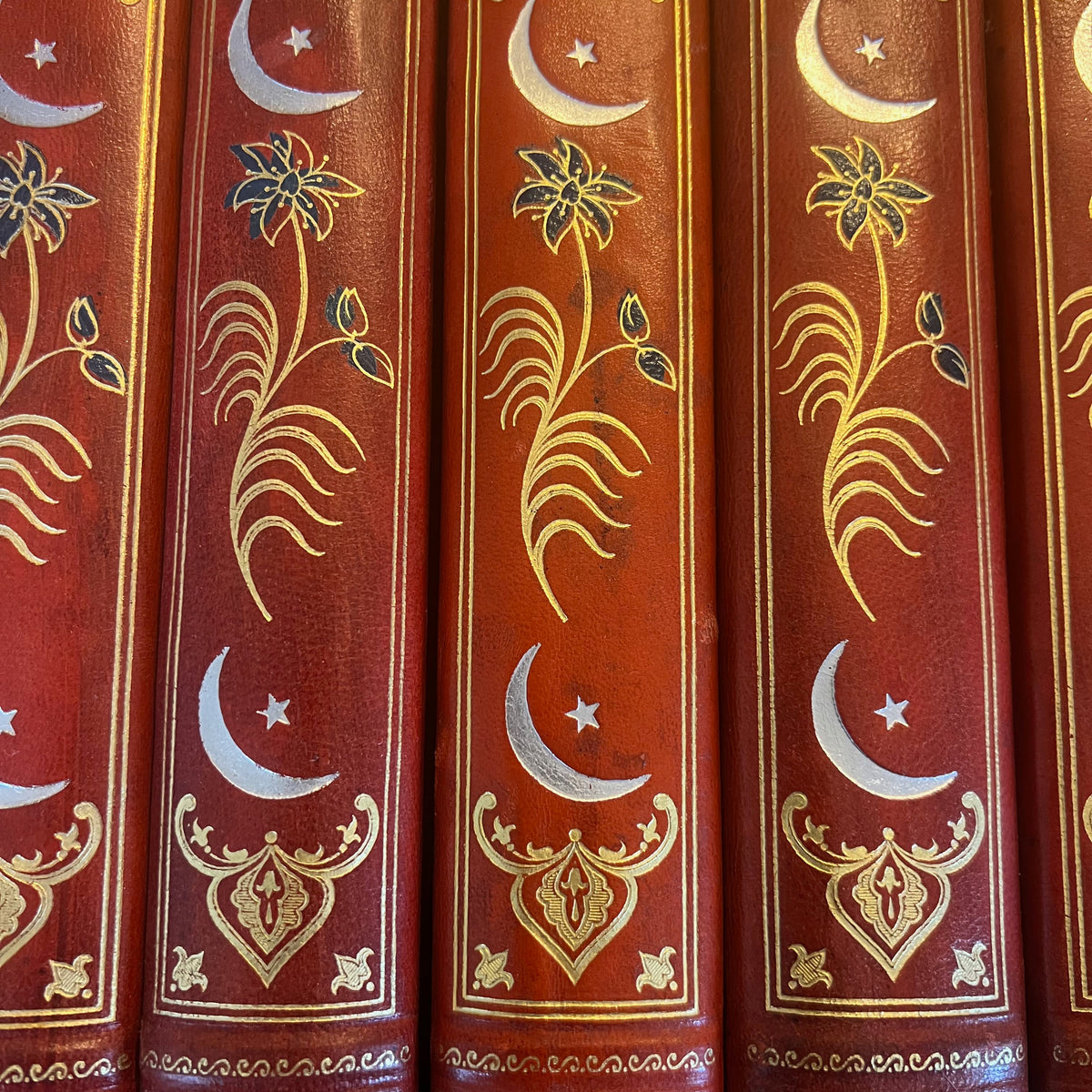 Détail de : Collection complète de huit volumes du Livre des Mille Nuits et Une Nuit de Mardrus, reliés en demi-veau rouge avec décor oriental doré.