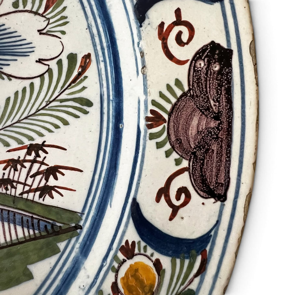 Détail de l'aile du plat ornée d'une frise continue de motifs floraux et végétaux stylisés.
