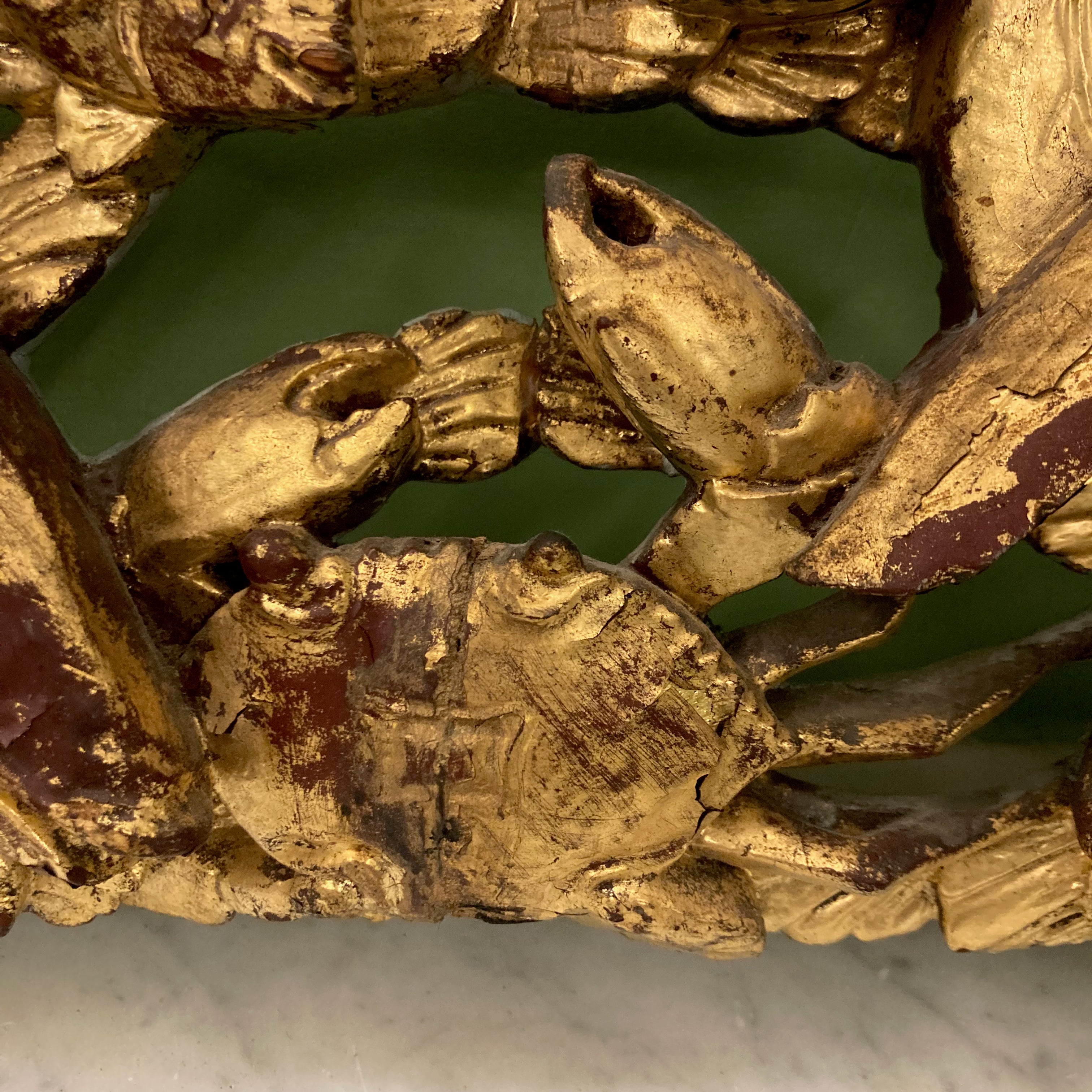 panneau décoratif en bois sculpté et doré à décor de poissons et d' un crabe.