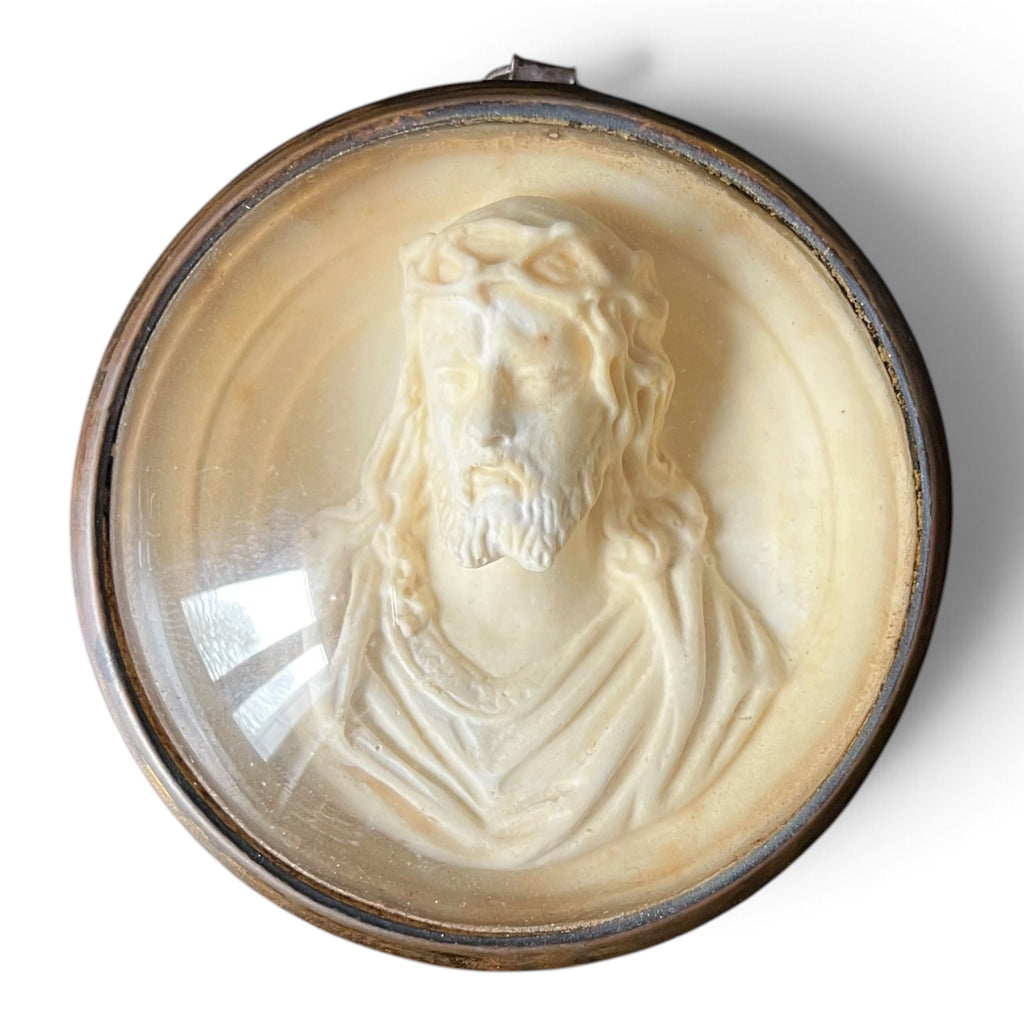 Médaillon circulaire d'époque fin XIXe siècle en laiton et verre bombé abritant un haut-relief représentant le Christ à la couronne d'épines.