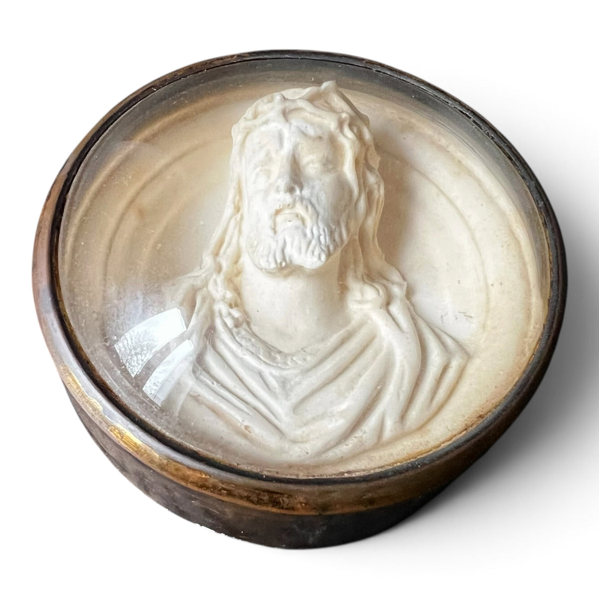 Médaillon circulaire d'époque fin XIXe siècle en laiton et verre bombé abritant un haut-relief représentant le Christ à la couronne d'épines.