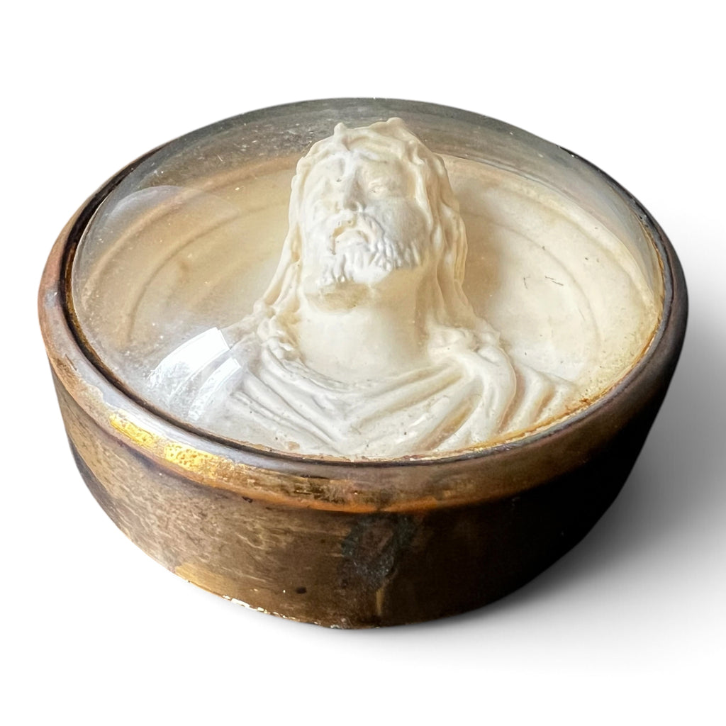 Médaillon circulaire d'époque fin XIXe siècle en laiton et verre bombé abritant un haut-relief représentant le Christ à la couronne d'épines.