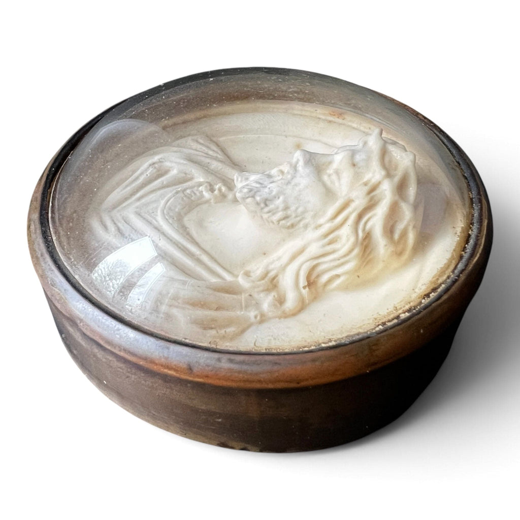 Médaillon circulaire d'époque fin XIXe siècle en laiton et verre bombé abritant un haut-relief représentant le Christ à la couronne d'épines.