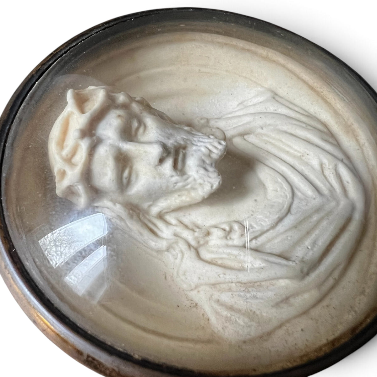 Médaillon circulaire d'époque fin XIXe siècle en laiton et verre bombé abritant un haut-relief représentant le Christ à la couronne d'épines.