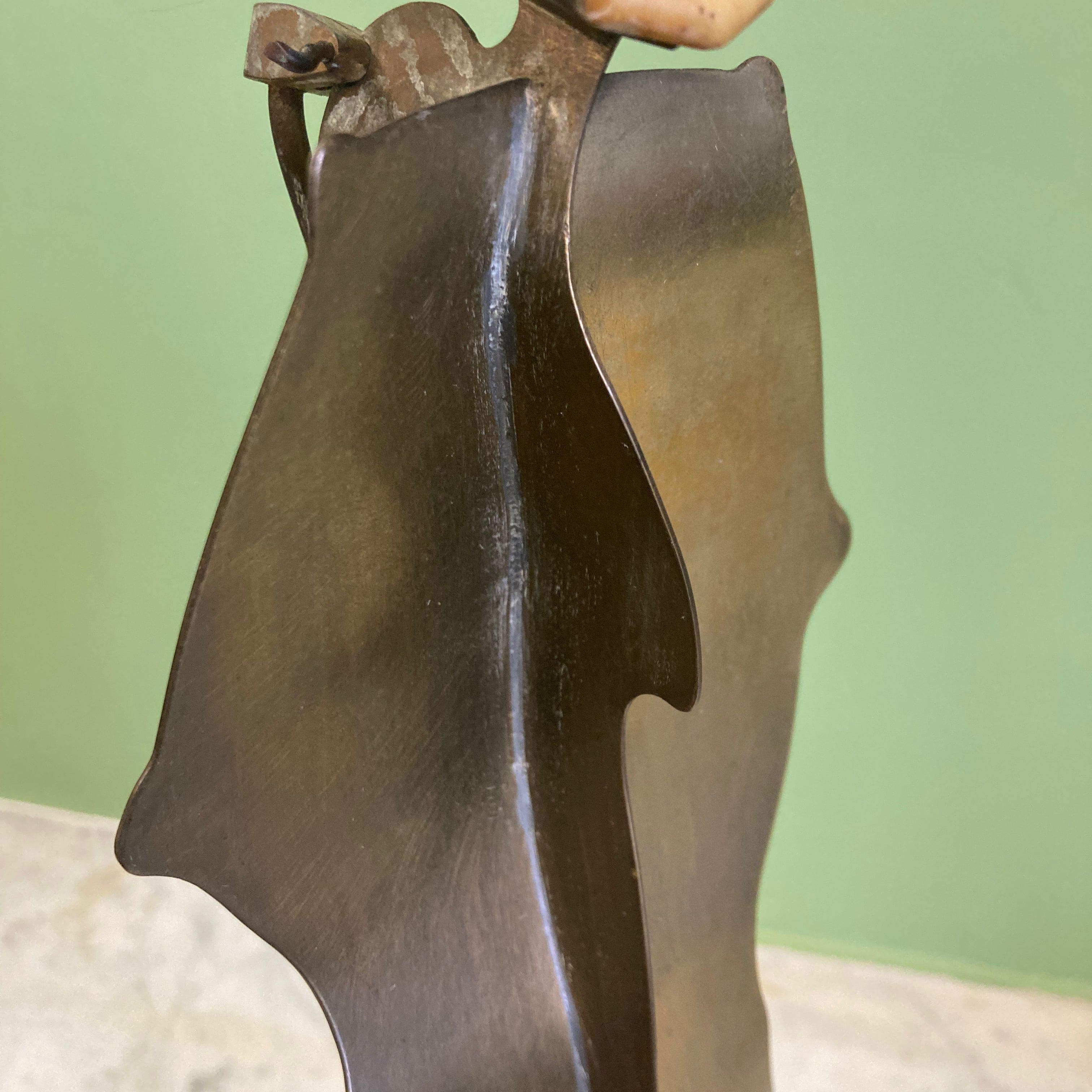 Sculpture représentant une vanité ou ne tête de mort en os, sur une base en métal en forme de flamme.