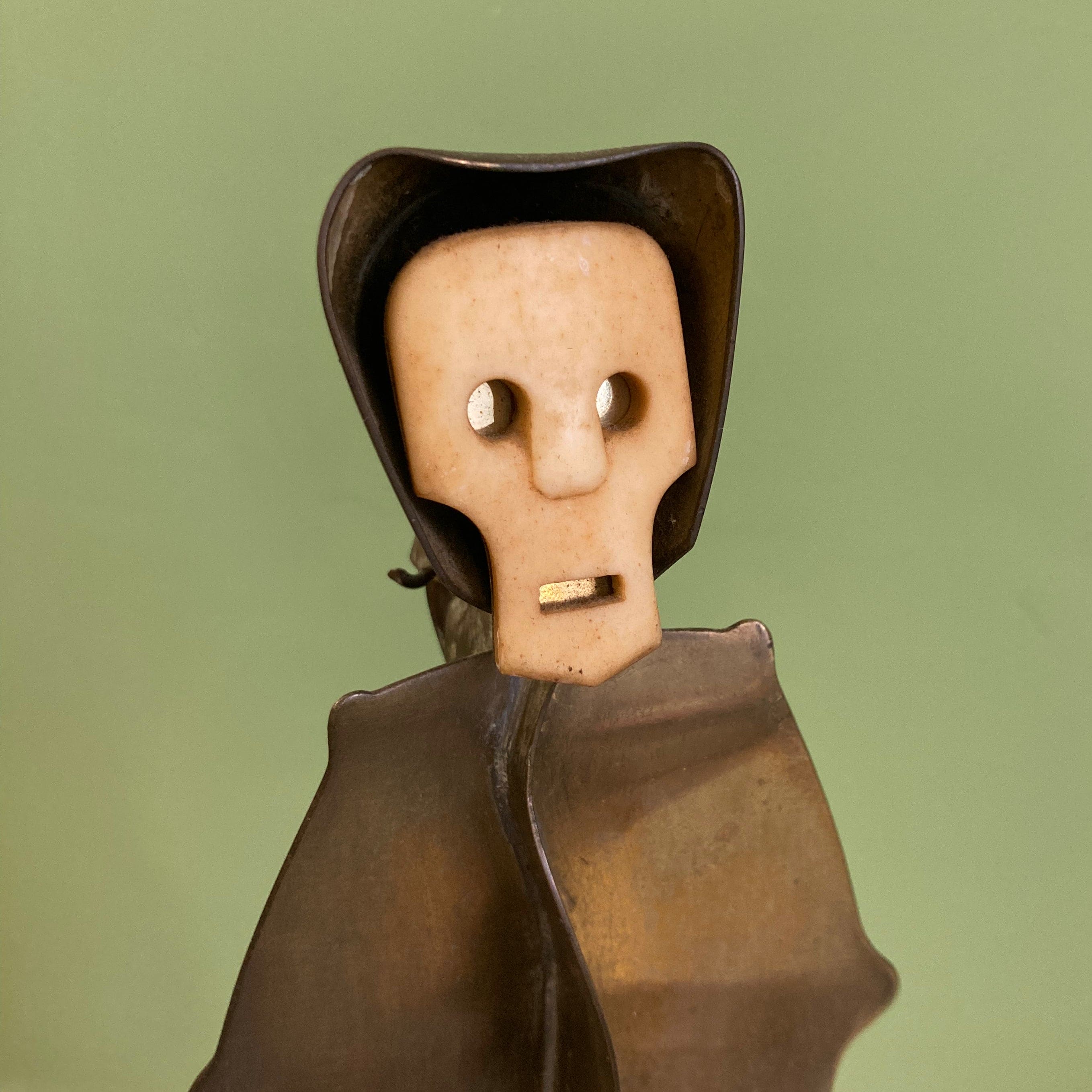 Sculpture représentant une vanité ou ne tête de mort en os, sur une base en métal en forme de flamme.