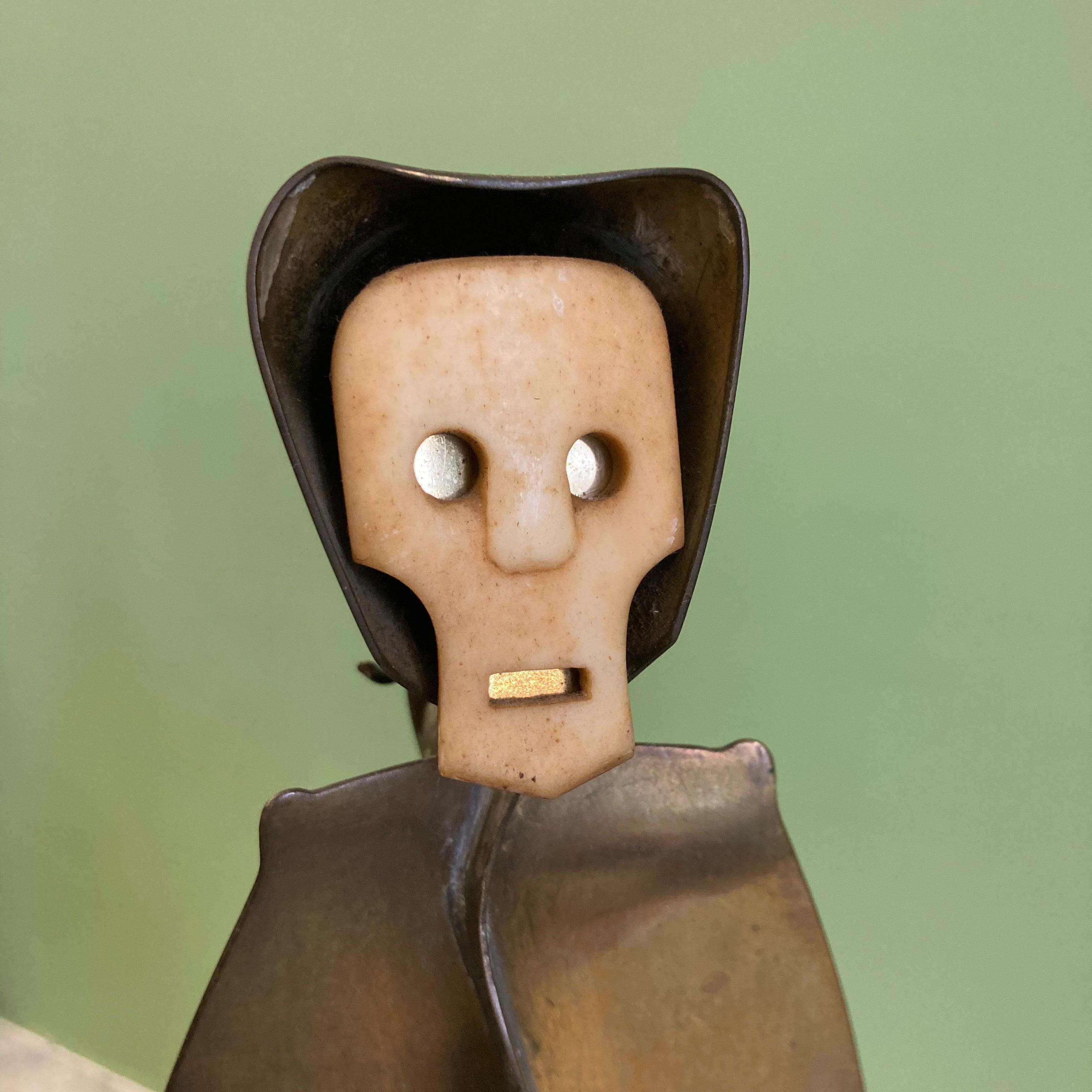 Sculpture représentant une vanité ou ne tête de mort en os, sur une base en métal en forme de flamme.