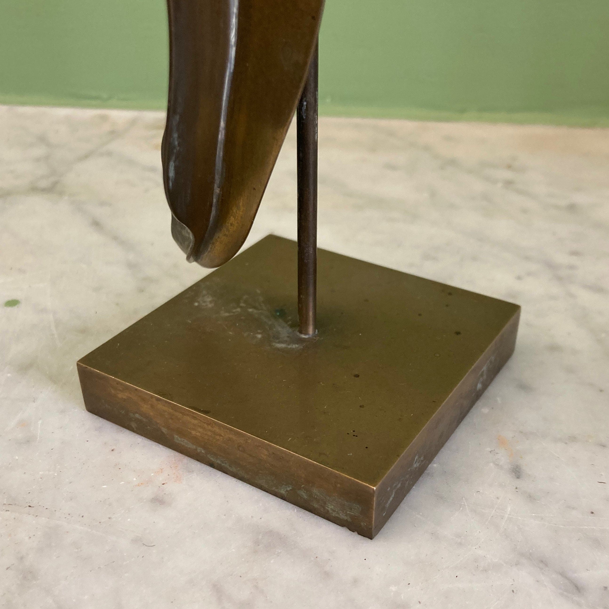 Sculpture représentant une vanité ou ne tête de mort en os, sur une base en métal en forme de flamme.