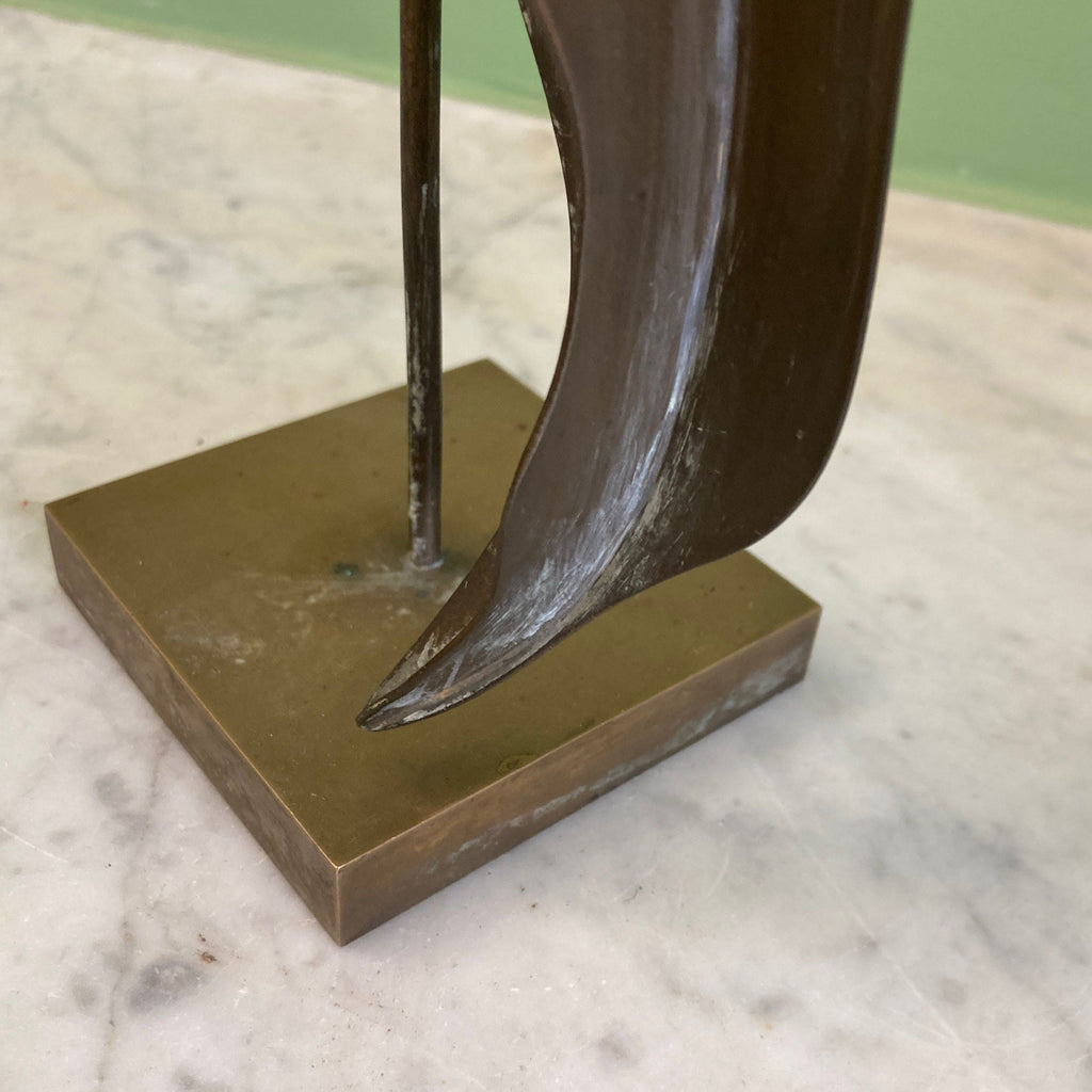 Sculpture représentant une vanité ou ne tête de mort en os, sur une base en métal en forme de flamme.