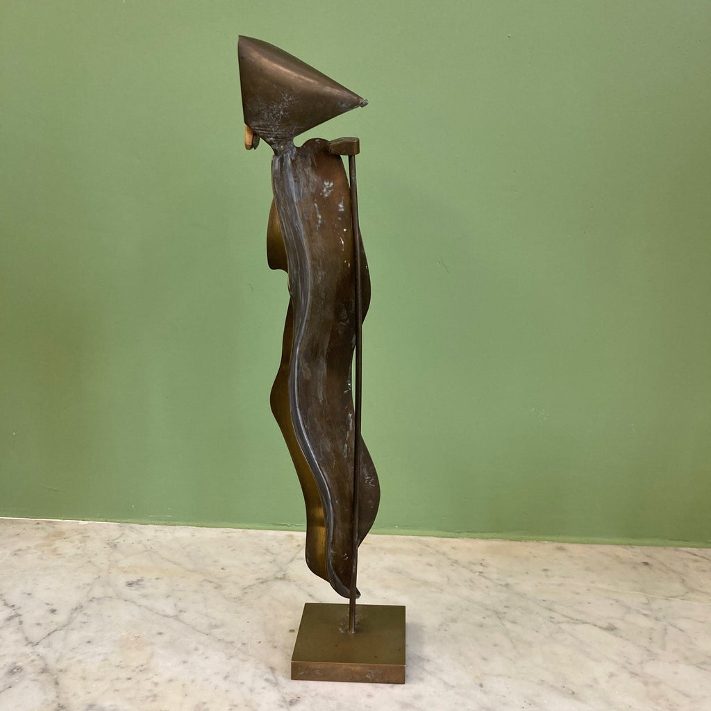 Sculpture représentant une vanité ou ne tête de mort en os, sur une base en métal en forme de flamme.