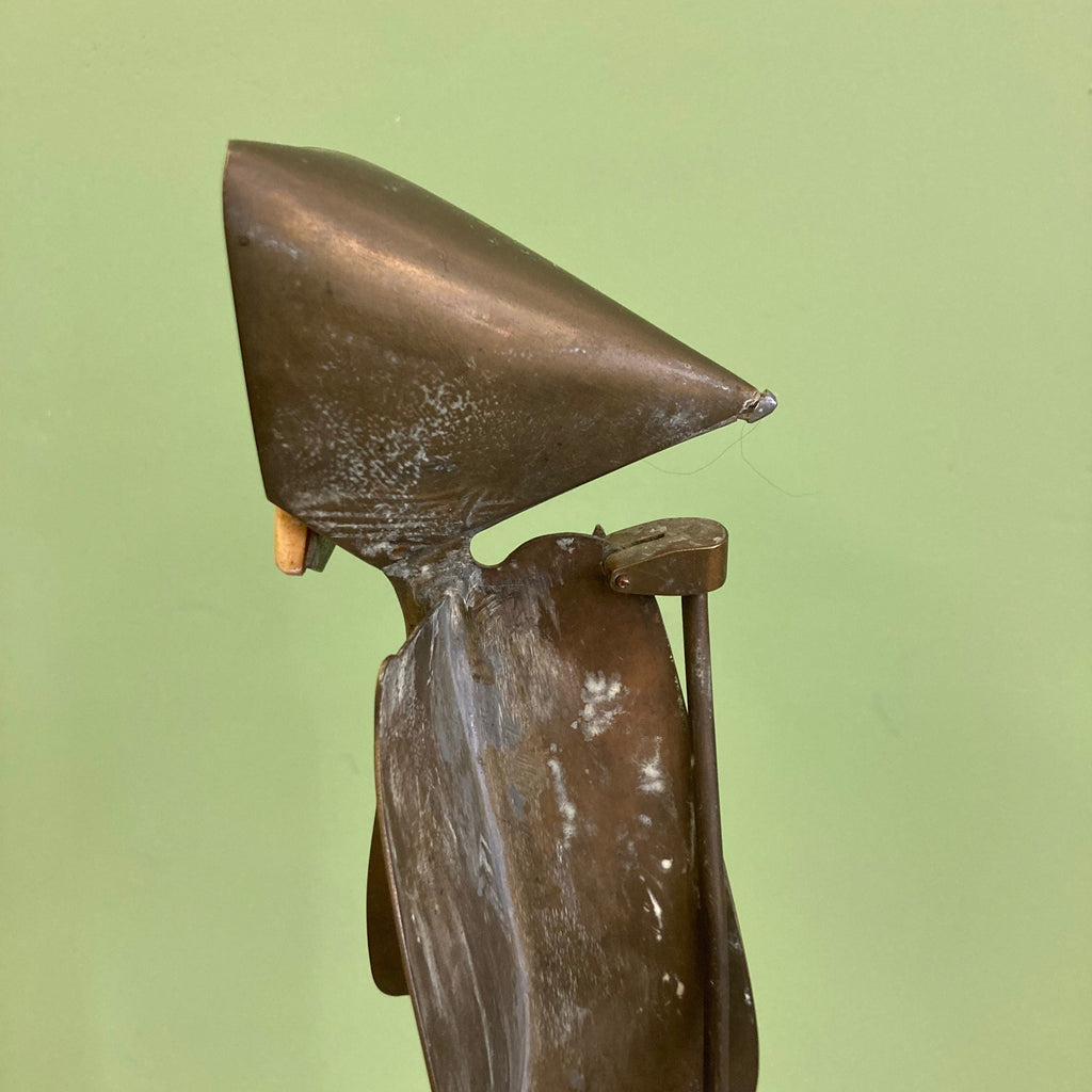 Sculpture représentant une vanité ou ne tête de mort en os, sur une base en métal en forme de flamme.