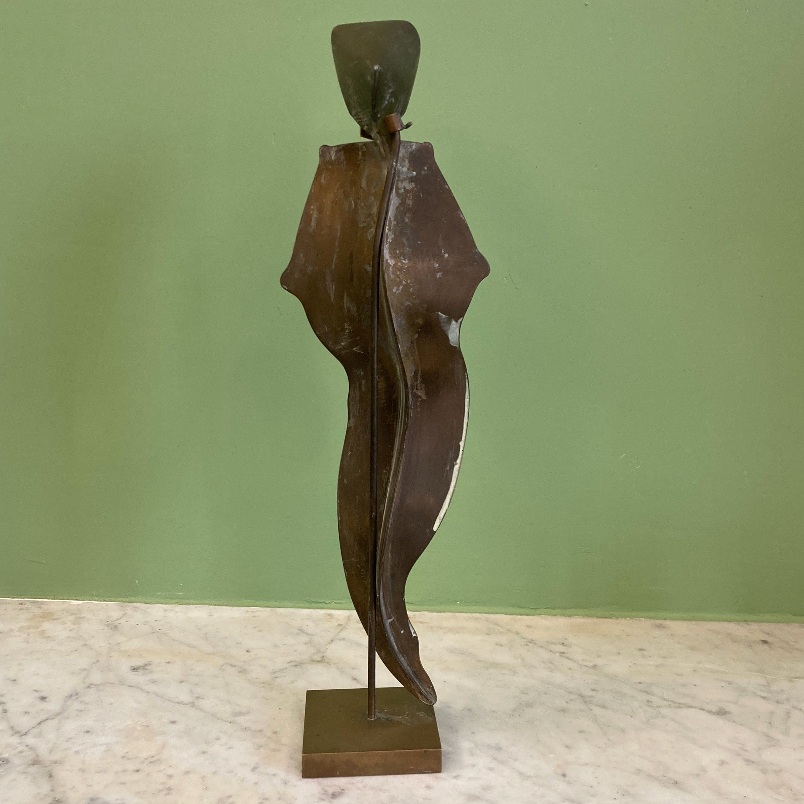 Sculpture représentant une vanité ou ne tête de mort en os, sur une base en métal en forme de flamme.