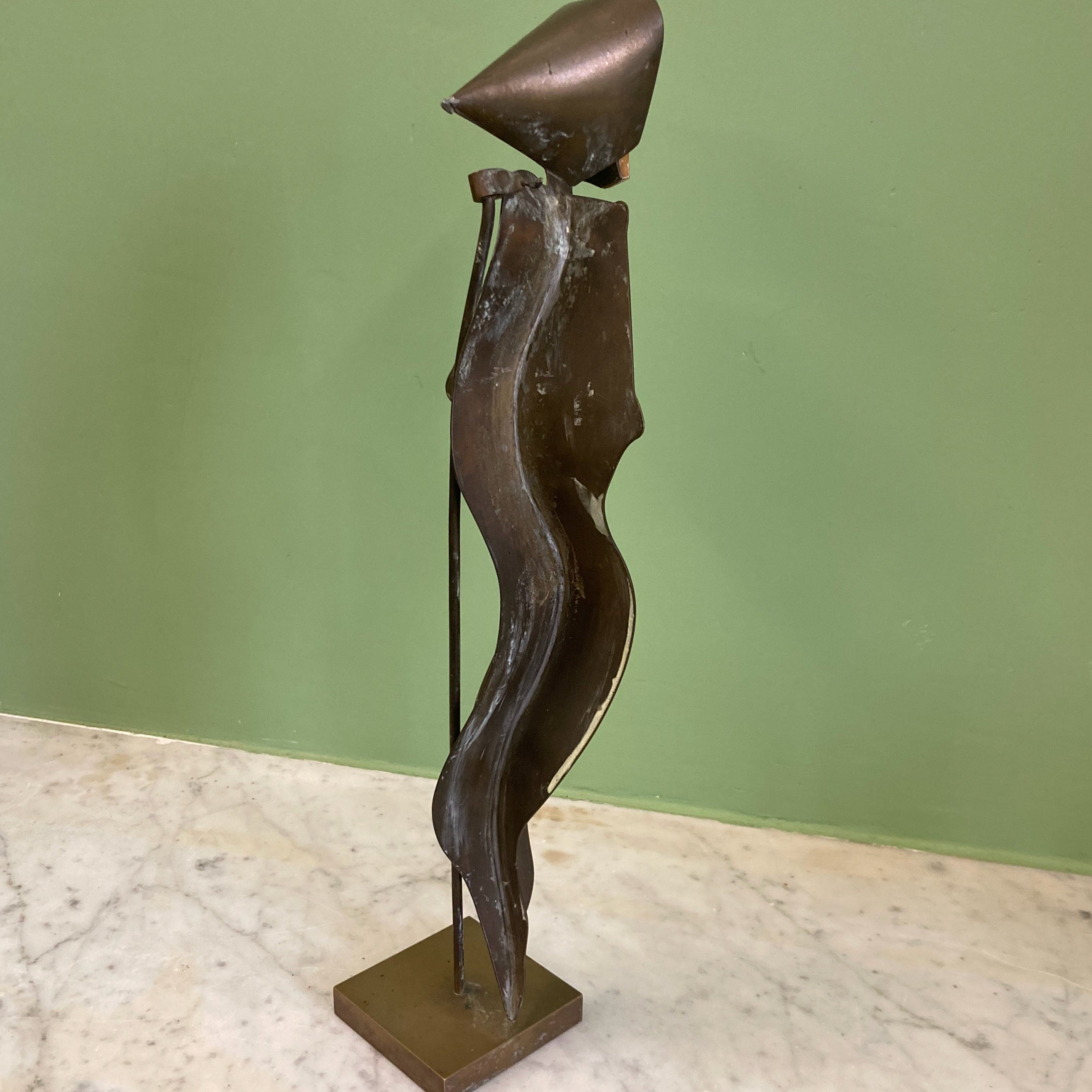 Sculpture représentant une vanité ou ne tête de mort en os, sur une base en métal en forme de flamme.