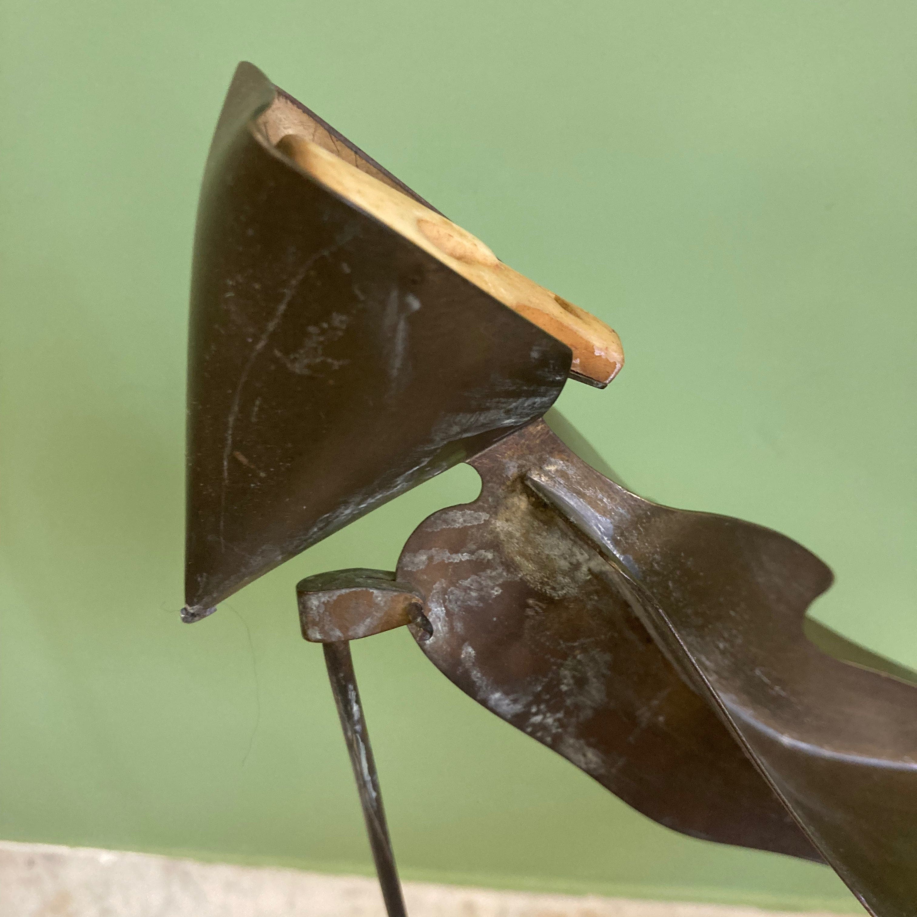 Sculpture représentant une vanité ou ne tête de mort en os, sur une base en métal en forme de flamme.