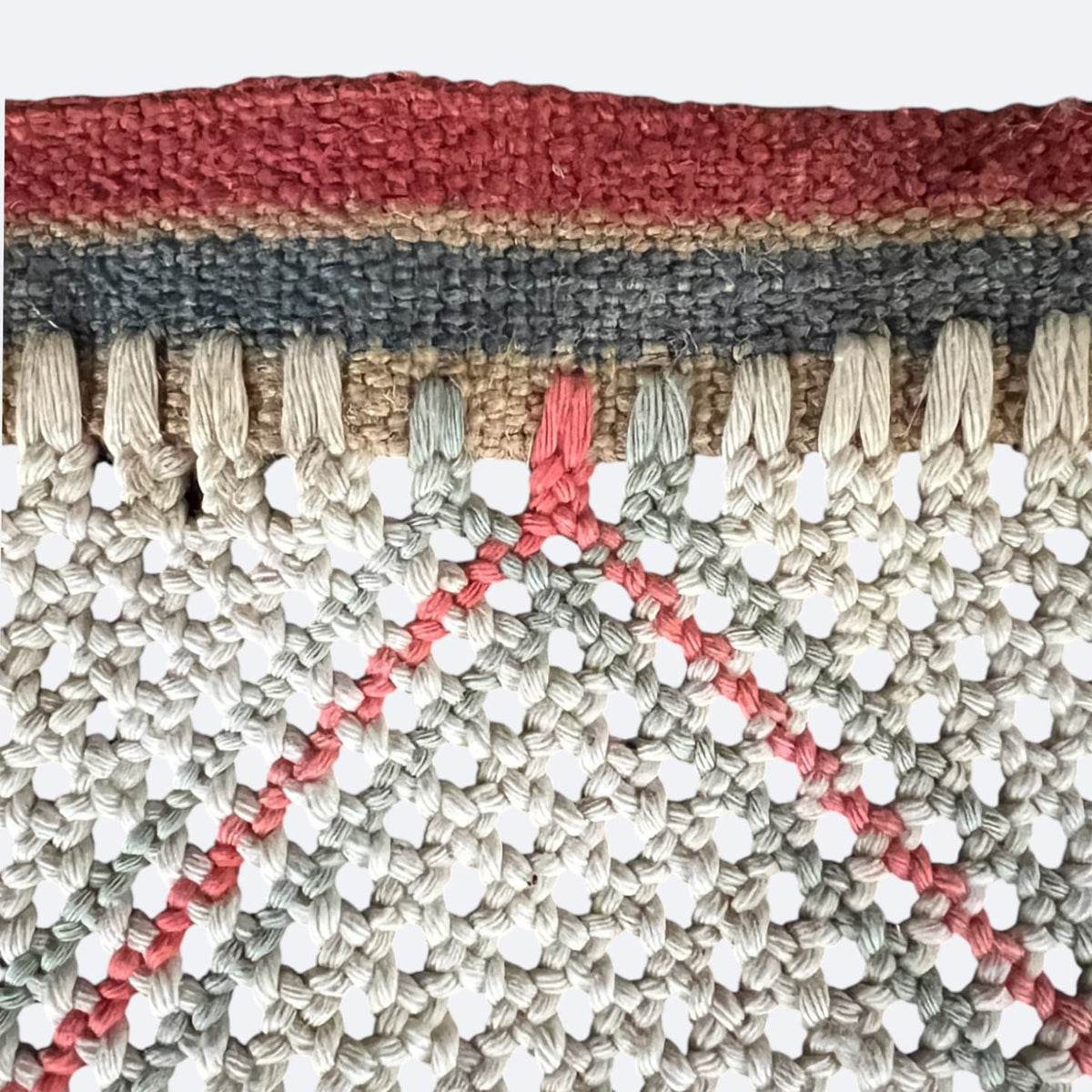 Détail des mailles en losanges rouges et gris d'une émouchette à bœufs ancienne de Chalosse.